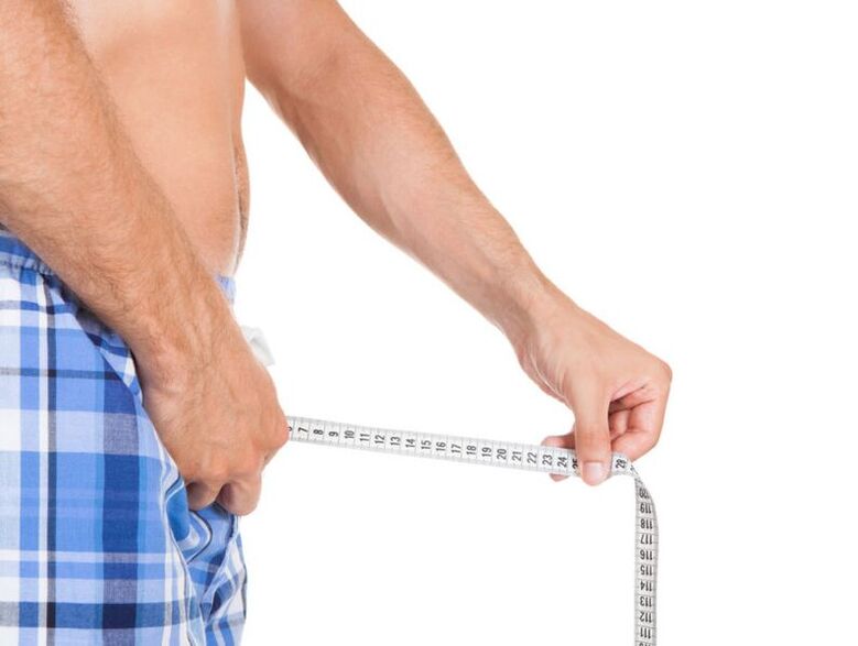 man measuring his penis with a centimeter